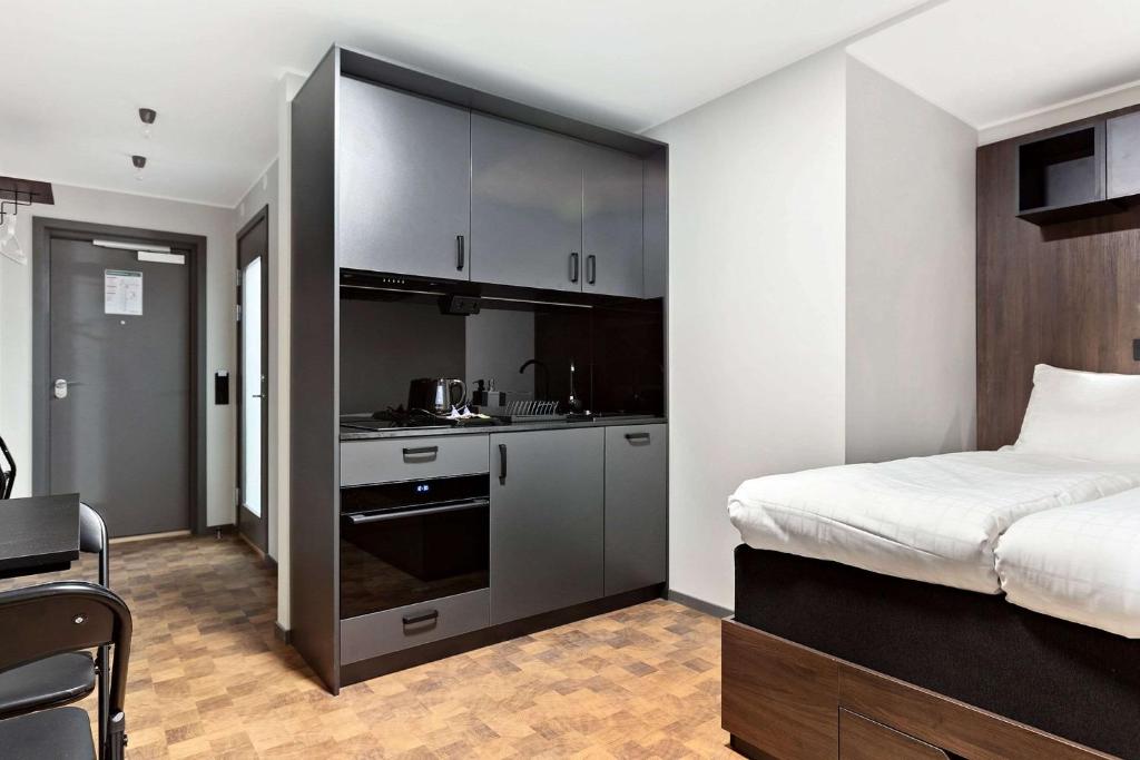 a bedroom with a bed and a kitchen in it at Sure Hotel Studio by Best Western Bromma in Stockholm