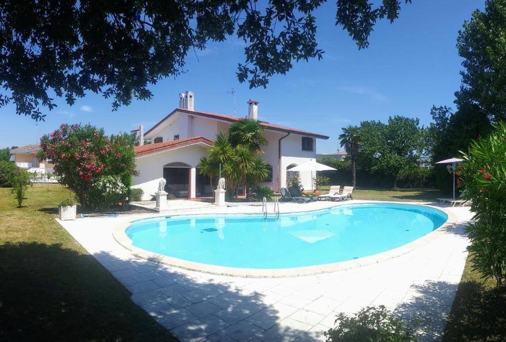 una gran piscina frente a una casa en Villa Mischa, en Bevazzana