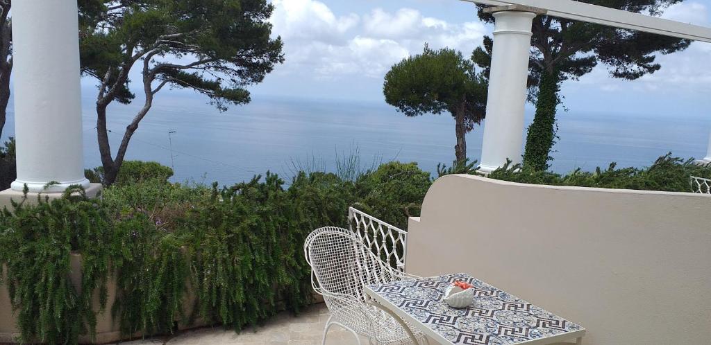 a white chair sitting on a porch with a view of the ocean at Hotel Orsa Maggiore in Anacapri