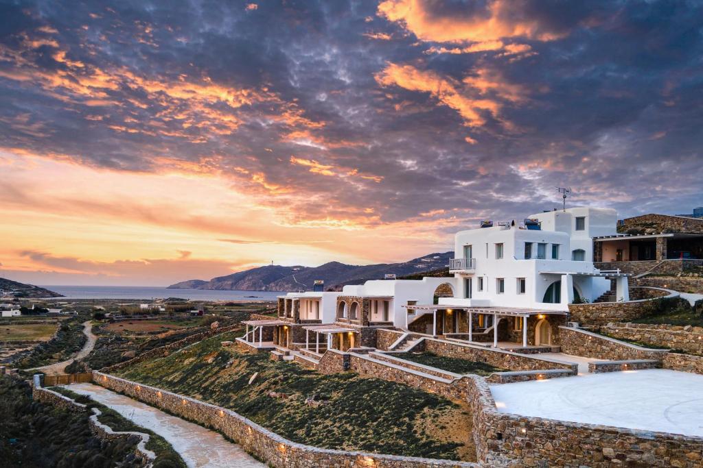 una casa en el acantilado con una puesta de sol en el fondo en Koumi Homes Mykonos, en Ftelia