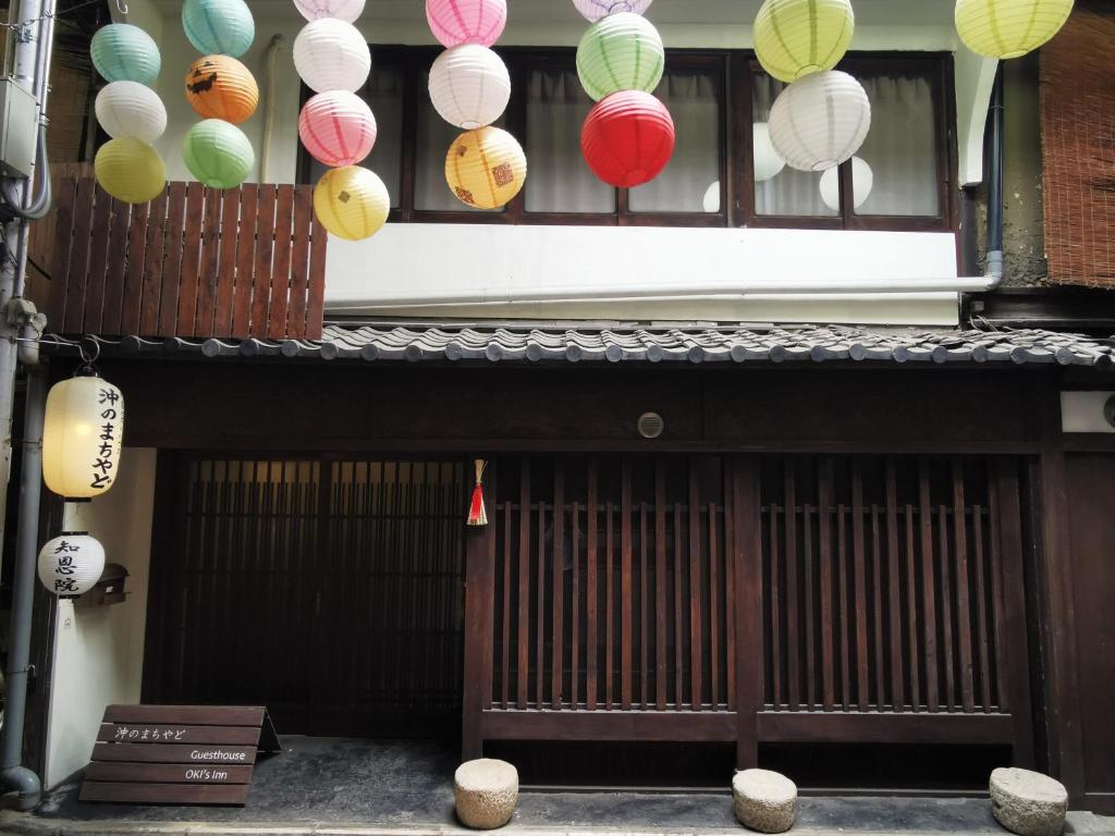 un bâtiment avec des lanternes en papier suspendues au-dessus d'une porte dans l'établissement OKI's Inn, à Kyoto