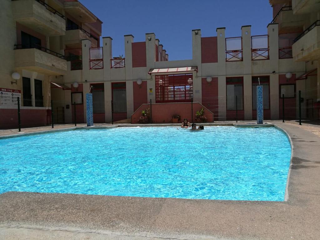 une grande piscine en face d'un bâtiment dans l'établissement Arinaga Beach & Pool Apartment, à Arinaga