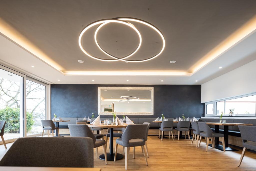 a dining room with tables and chairs and a large mirror at Hotel Restaurant Sennerbad in Ravensburg