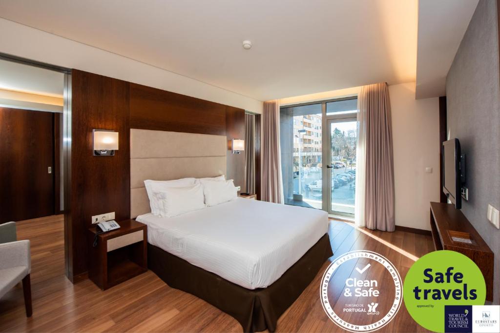 a hotel room with a large bed and a large window at Eurostars Oporto in Porto