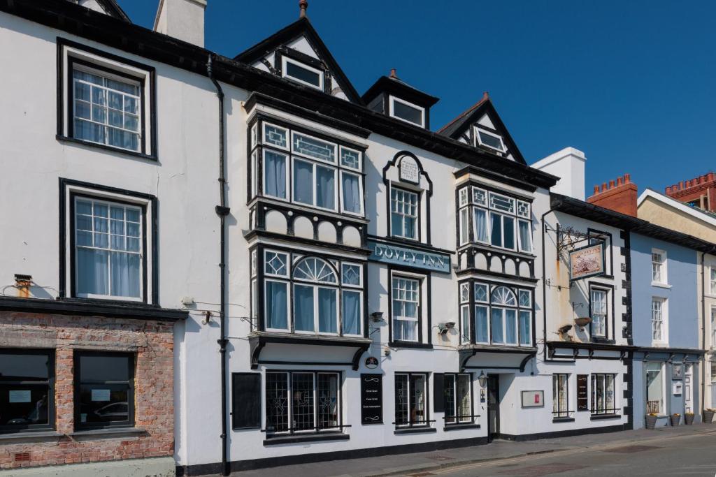 a row of white and black buildings on a street at Dovey Inn in Aberdyfi