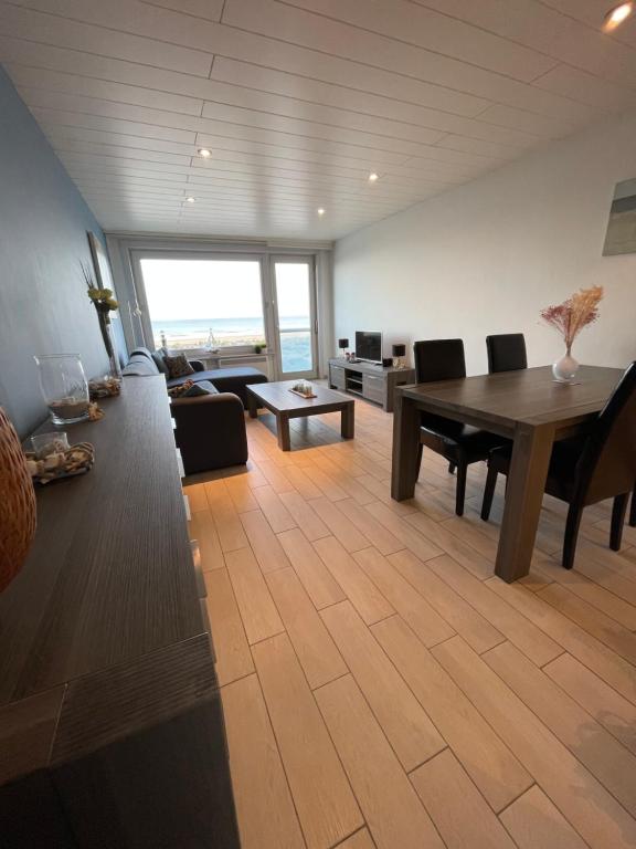 een woonkamer met een tafel en een bank bij Studio zeezicht Nieuwpoort in Nieuwpoort