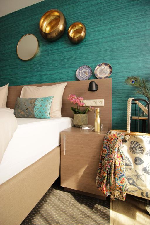 a bedroom with a bed and a green wall at Zeevonk Studio's & Appartementen in Katwijk aan Zee