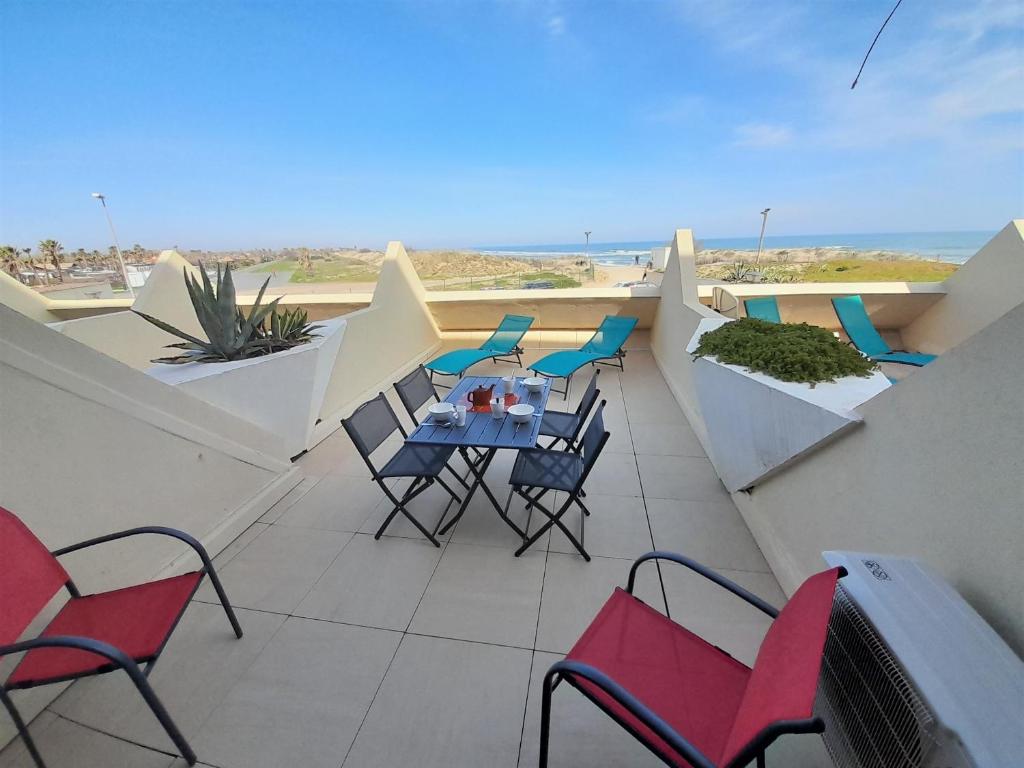 um pátio com uma mesa e cadeiras e o oceano em Appartement Village Naturiste Paradoxe em Cap d'Agde