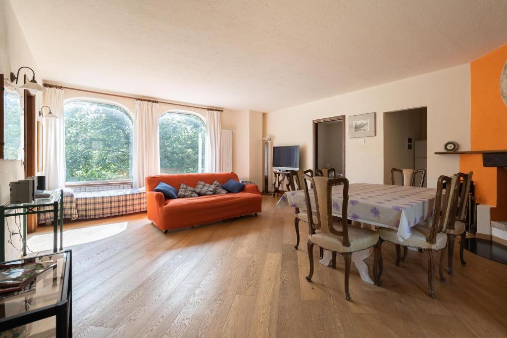 - un salon avec un canapé orange et une table dans l'établissement Il Giardino del Sole - Lavanda, à Garlenda