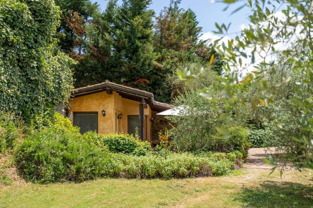 una pequeña casa amarilla en medio de un patio en Il Giardino del Sole, Chalet Salvia, en Garlenda