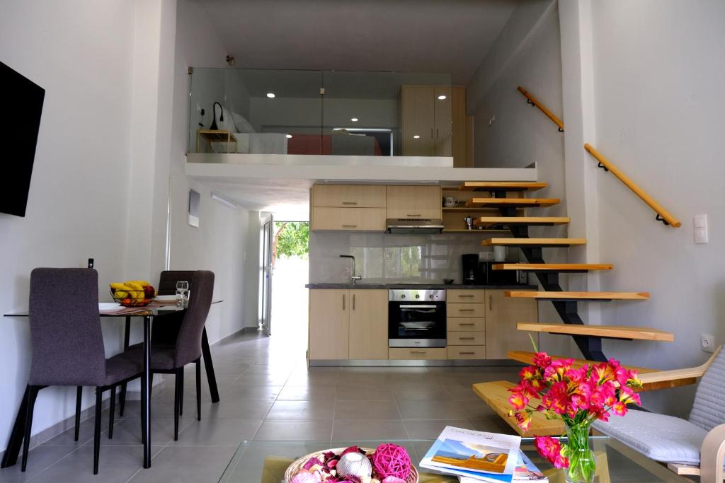 a kitchen with a staircase and a table with chairs at Erinaki Apartments in Kissamos