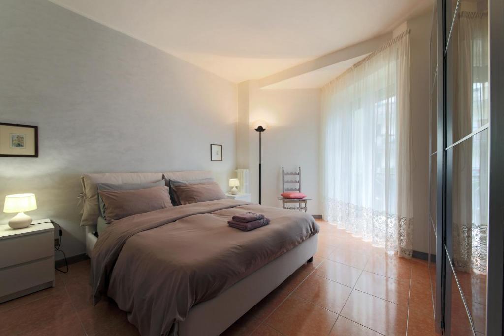 1 dormitorio con cama grande y ventana grande en Private parking - Family home - 15 min to Venice en Mestre