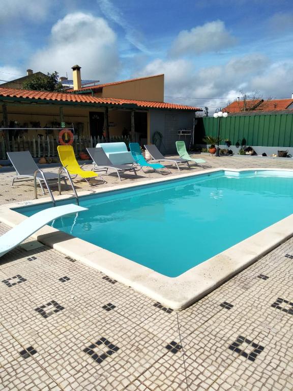 une grande piscine avec des chaises et un bâtiment dans l'établissement Your HOME ECO & NATUR, à Carvide