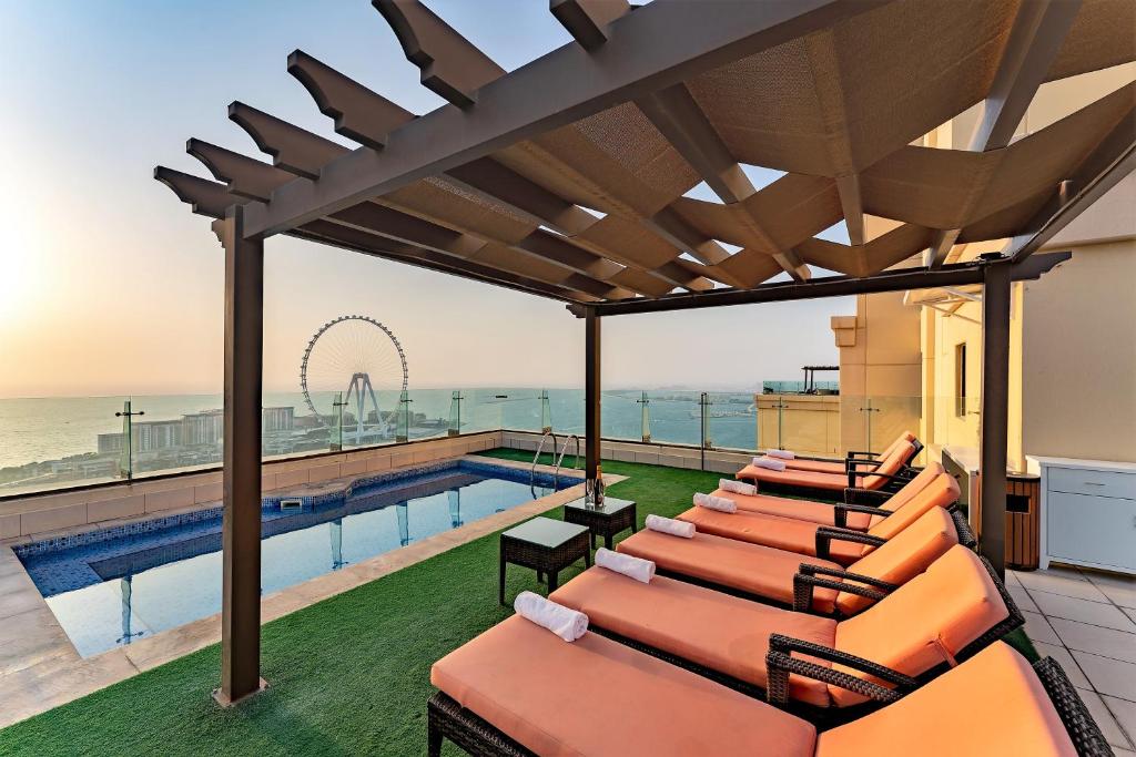 a group of lounge chairs on the roof of a building at Jbr penthouse with terrace pool in Dubai