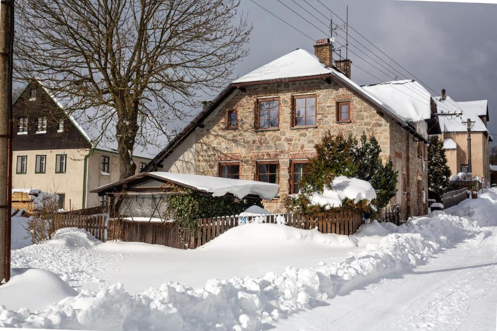 een huis is bedekt met sneeuw bij Chata Plešivka in Abertamy
