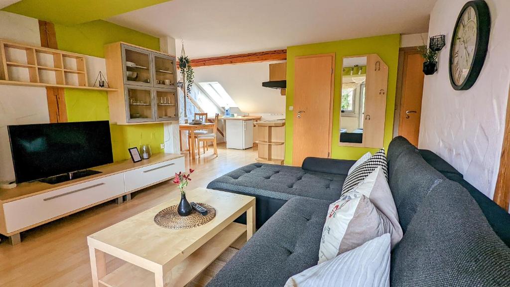 a living room with a blue couch and a tv at Ferienwohnung Schwalbennest am Igelsbachsee in Absberg