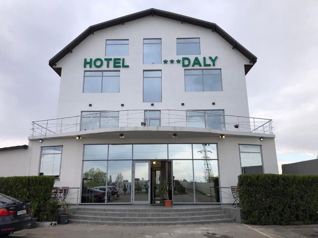 プロイェシュティにあるHotel Dalyのホテルの日を読む看板のあるホテルの建物