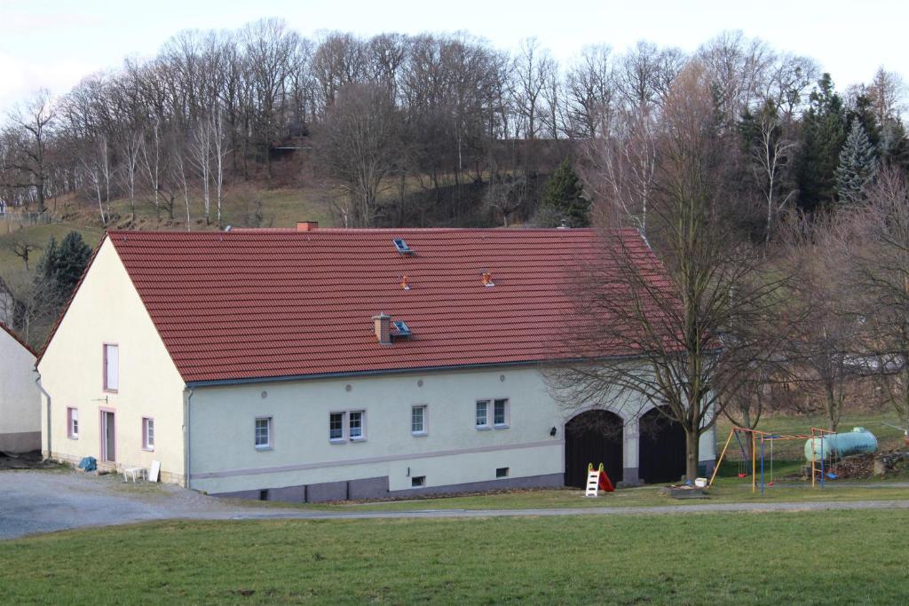a large white barn with a red roof at Ferienhof Wiesenblick in Pirna