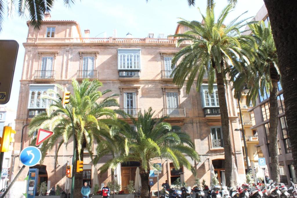 un grand bâtiment avec des palmiers devant lui dans l'établissement Life Apartments Alameda Colón, à Malaga