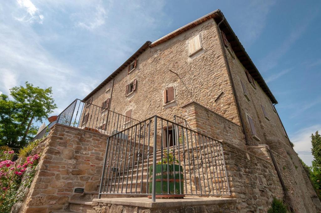 un antiguo edificio de ladrillo con una puerta de metal en Castello Montesasso, en Mercato Saraceno