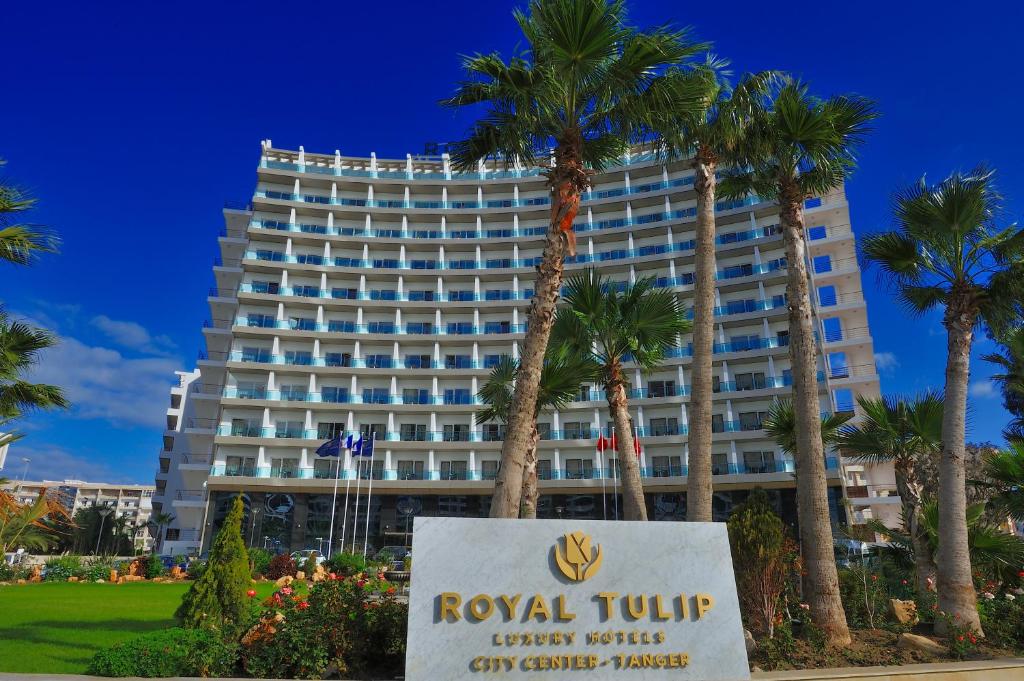 a hotel with a sign in front of a building at Royal Tulip City Center in Tangier