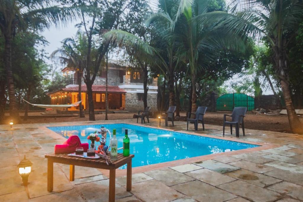 - une piscine avec une table à côté d'une maison dans l'établissement Casa Heritage, à Lonavala