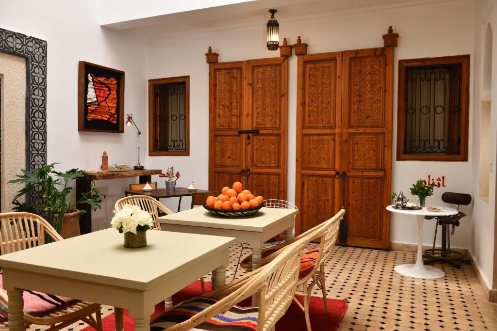 a dining room table with a bowl of oranges on it at Riad Lamzia in Marrakesh