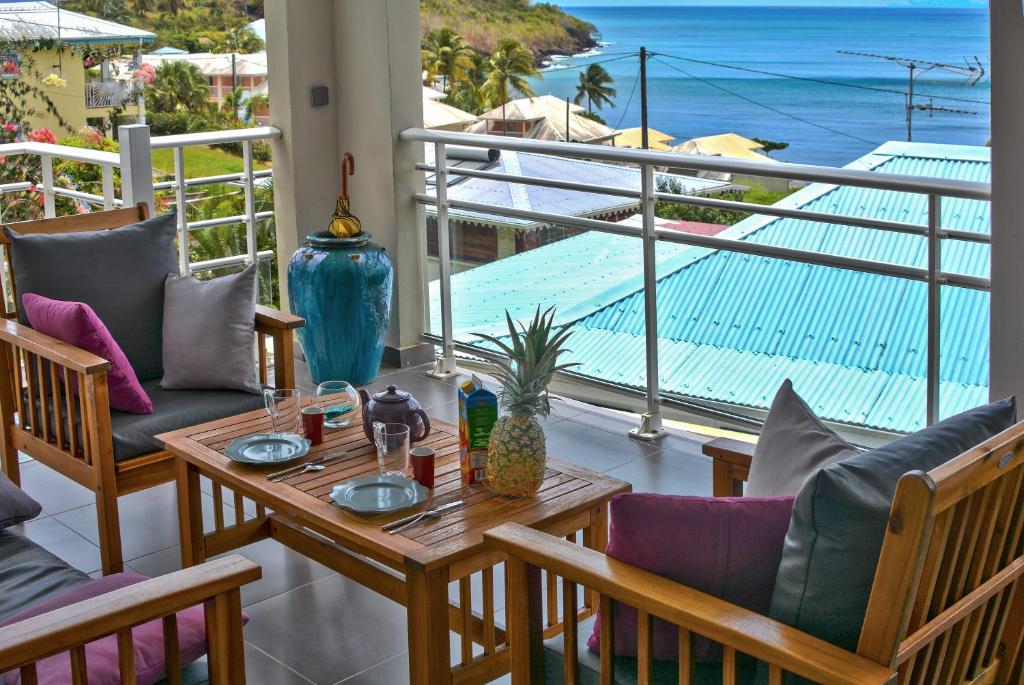 a balcony with a table and chairs and a view of the ocean at Alyzes Diamant in Le Diamant