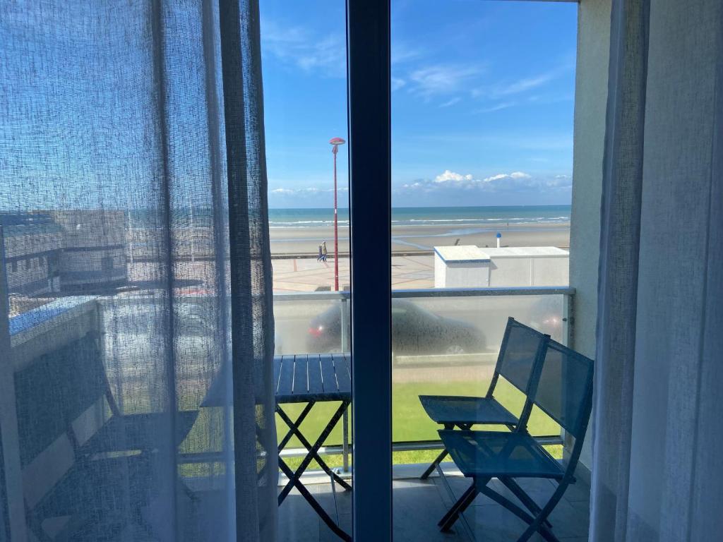 a balcony with a chair and a view of the ocean at Appartement Face à la mer in Wimereux