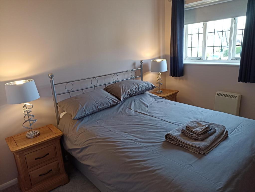 a bedroom with a bed with two lamps and a tray on it at Froden Court in Billericay