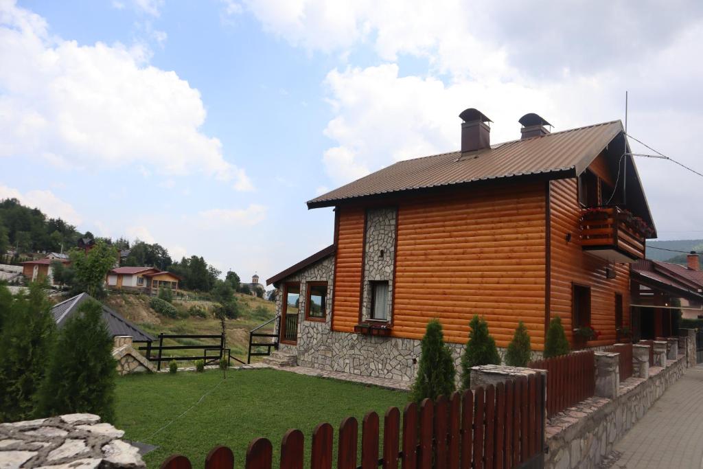 una casa de madera con una valla delante en Villa Beti, en Mavrovo