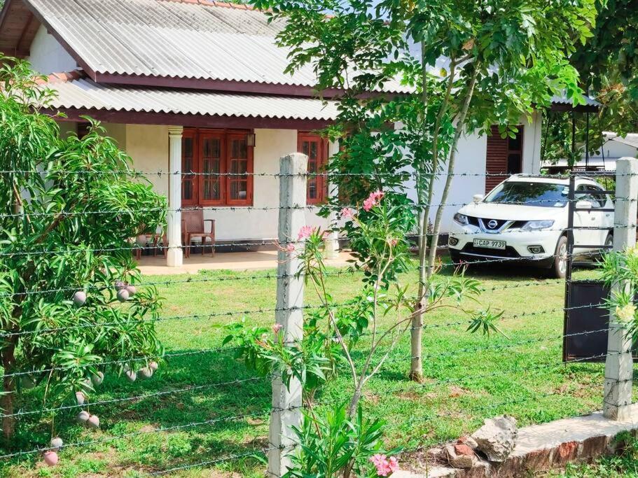 a car parked in front of a house with a fence at Saubagya Residence - Air Port View in Anuradhapura