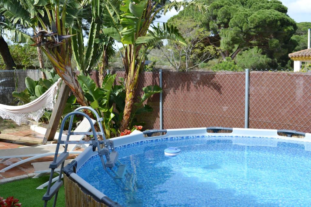 a swimming pool in a yard next to a fence at 3 bedrooms house with private pool enclosed garden and wifi at El Soto in El Cañal