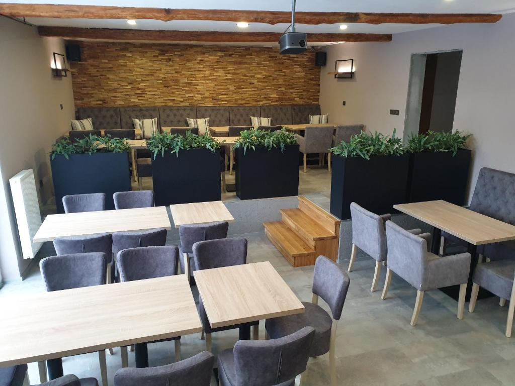 jadalnia ze stołami, krzesłami i roślinami w obiekcie Penzion Diana w mieście Bedřichov