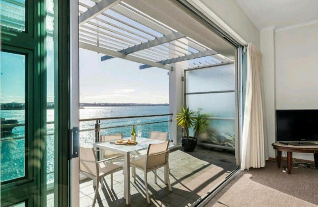 uma sala de jantar com vista para o oceano em Life on Water- Princes Wharf apartment with fabulous views em Auckland