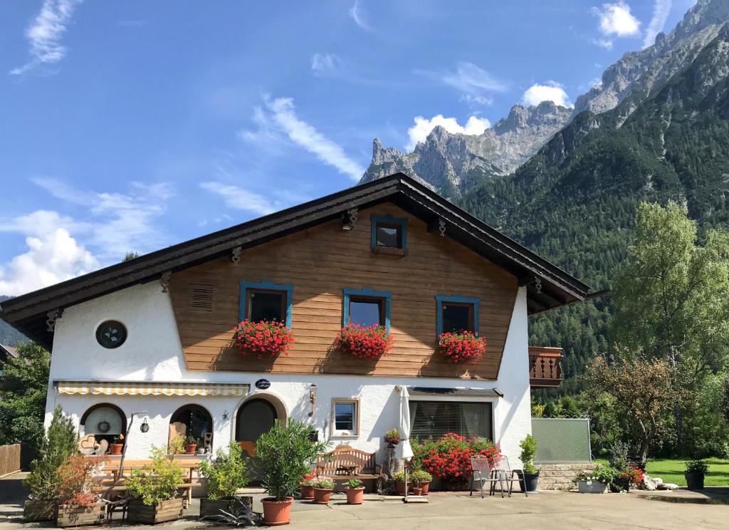 a building with flower boxes on the front of it at Hotel Garni Gästehaus Edlhuber in Mittenwald