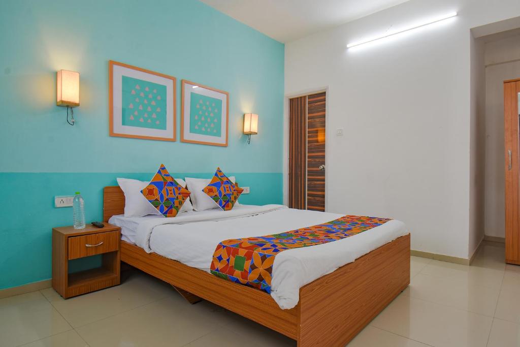 - une chambre avec un lit et un mur bleu dans l'établissement FabHotel Aakiyo, à Pune