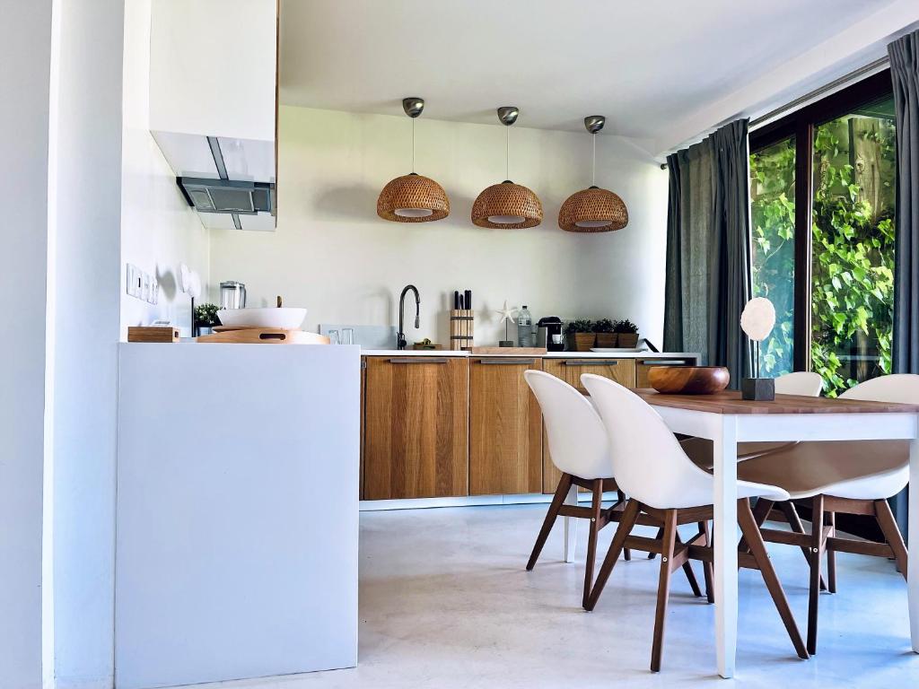 a kitchen and dining room with a table and chairs at Beach House Pedras D'el Rei in Santa Luzia