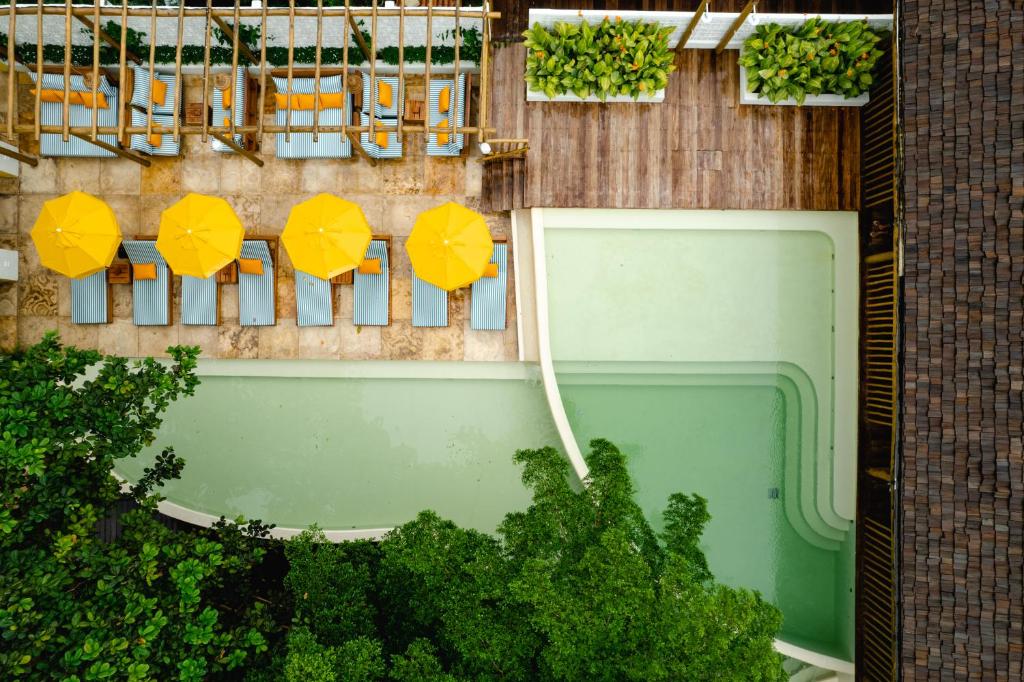 einen Blick über einen Pool mit gelben Sonnenschirmen in der Unterkunft Café Jeri Hotel in Jericoacoara