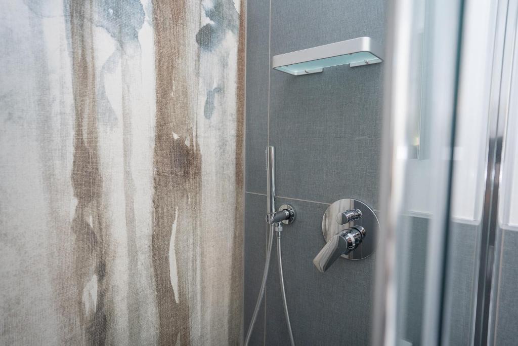 łazienka z prysznicem z zasłoną prysznicową w obiekcie Suite Raggio di Sole 023091-LOC-04058 w Weronie