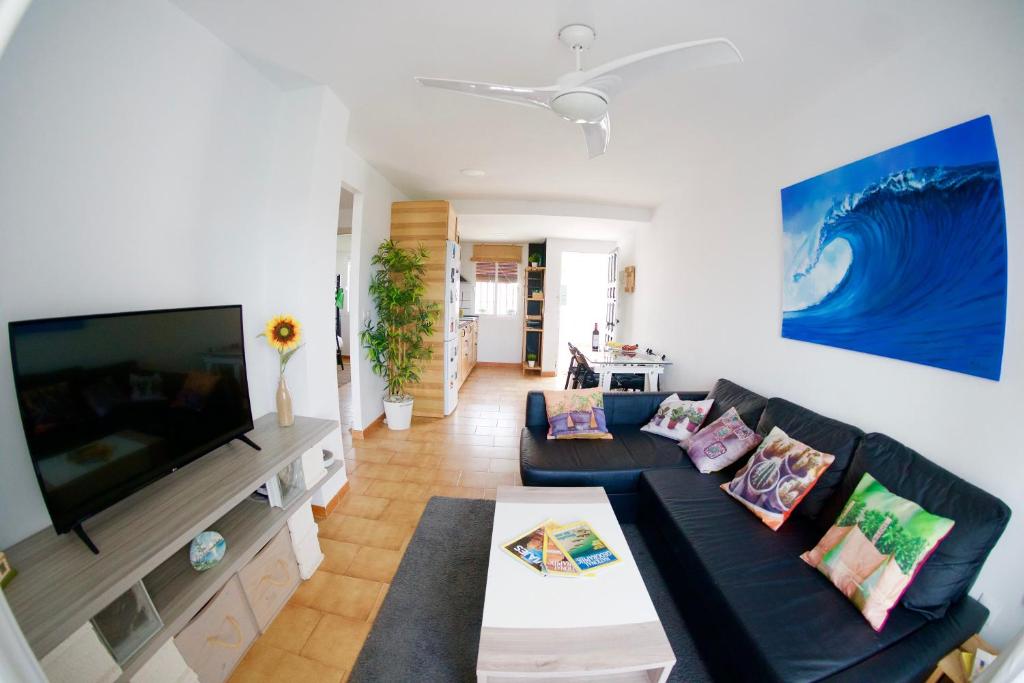 a living room with a couch and a large tv at "soñaC soL" in Los Caños de Meca