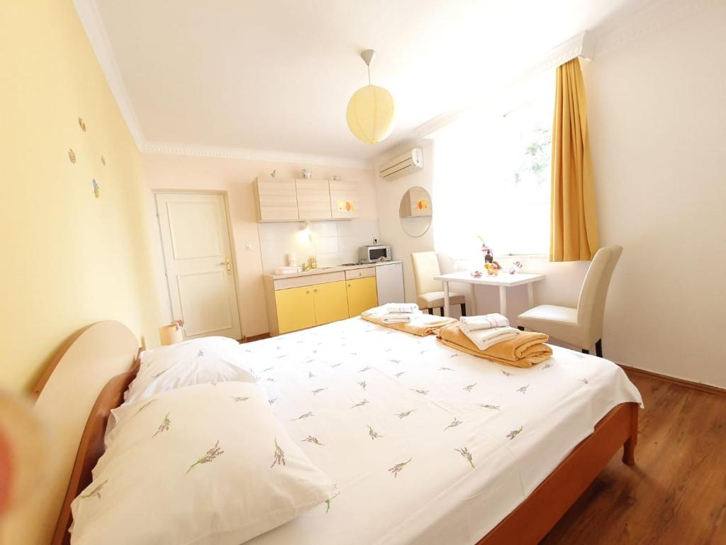 a bedroom with a bed and a kitchen with a window at Apartments Dabar in Dubrovnik