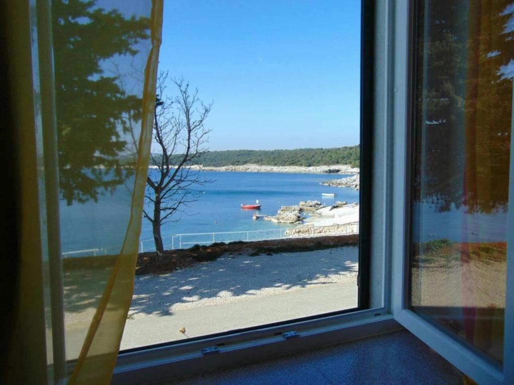 a window view of a beach from a house at Apartment Rajka - 20m from beach in Koromačno