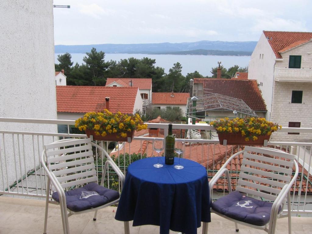 einen Tisch und Stühle auf einem Balkon mit Aussicht in der Unterkunft Apartments and rooms Mini - parking in Bol