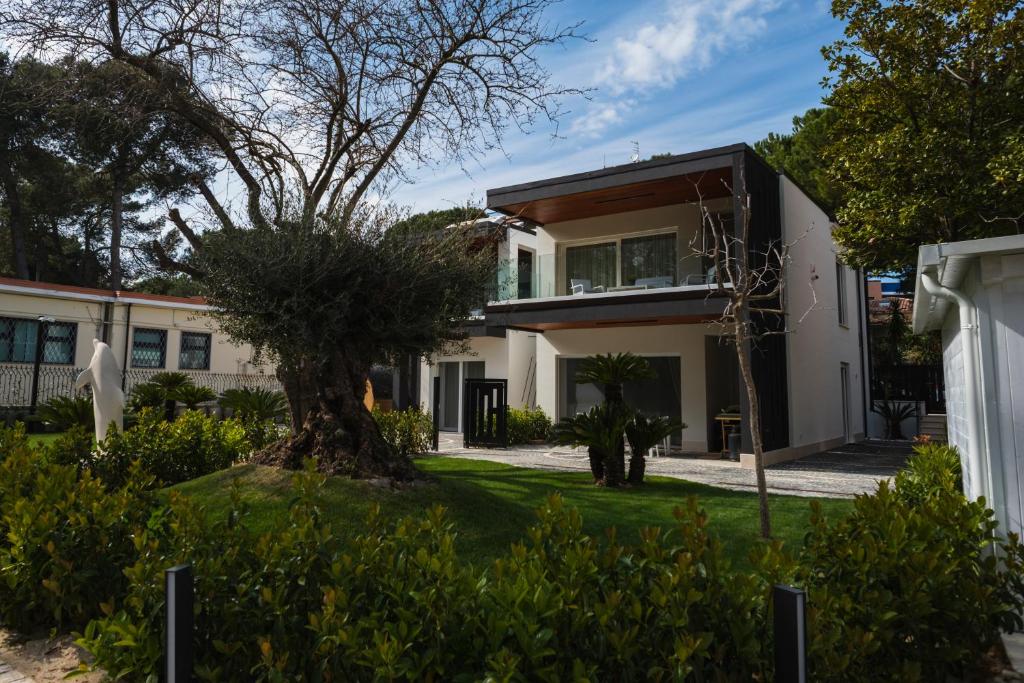 a house with a tree in the front yard at Luxury B&B La Riserva Dannunziana in Pescara
