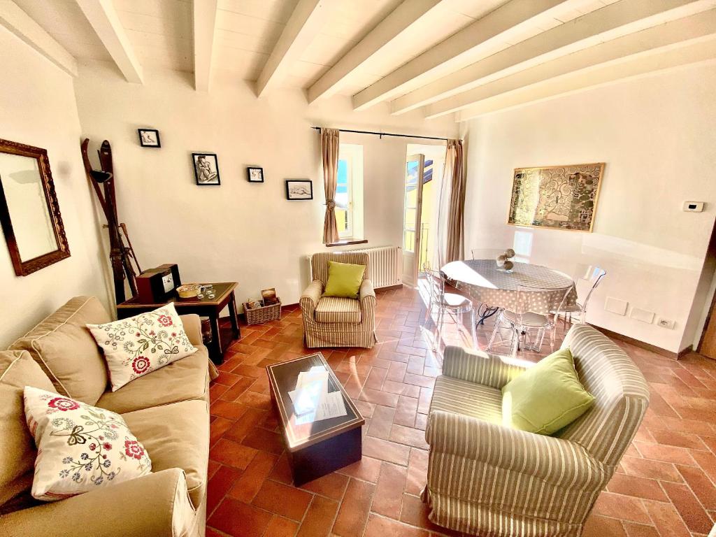 Una sala de estar con un sofá y sillas y una mesa. en Casa del lago, en Menaggio