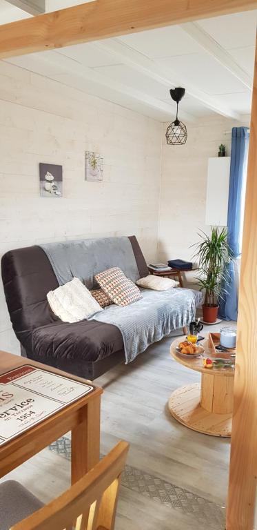 ein Wohnzimmer mit einem Sofa und einem Tisch in der Unterkunft Appartement au pied du port de St Quay Portrieux in Saint-Quay-Portrieux