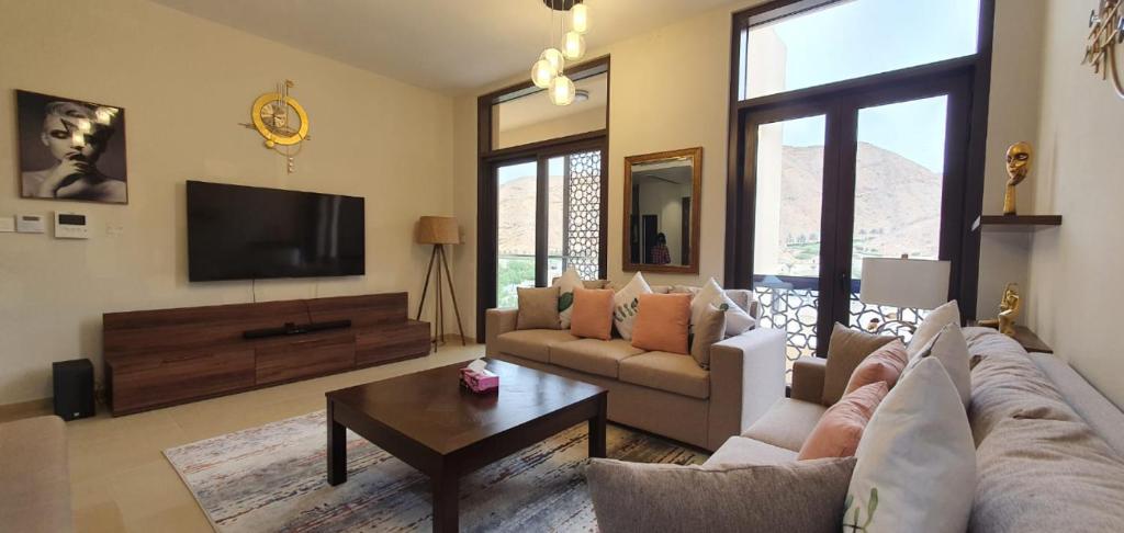 een woonkamer met een bank en een tv bij ONE Elegant Apartment in Muscat Bay 02 in Muscat