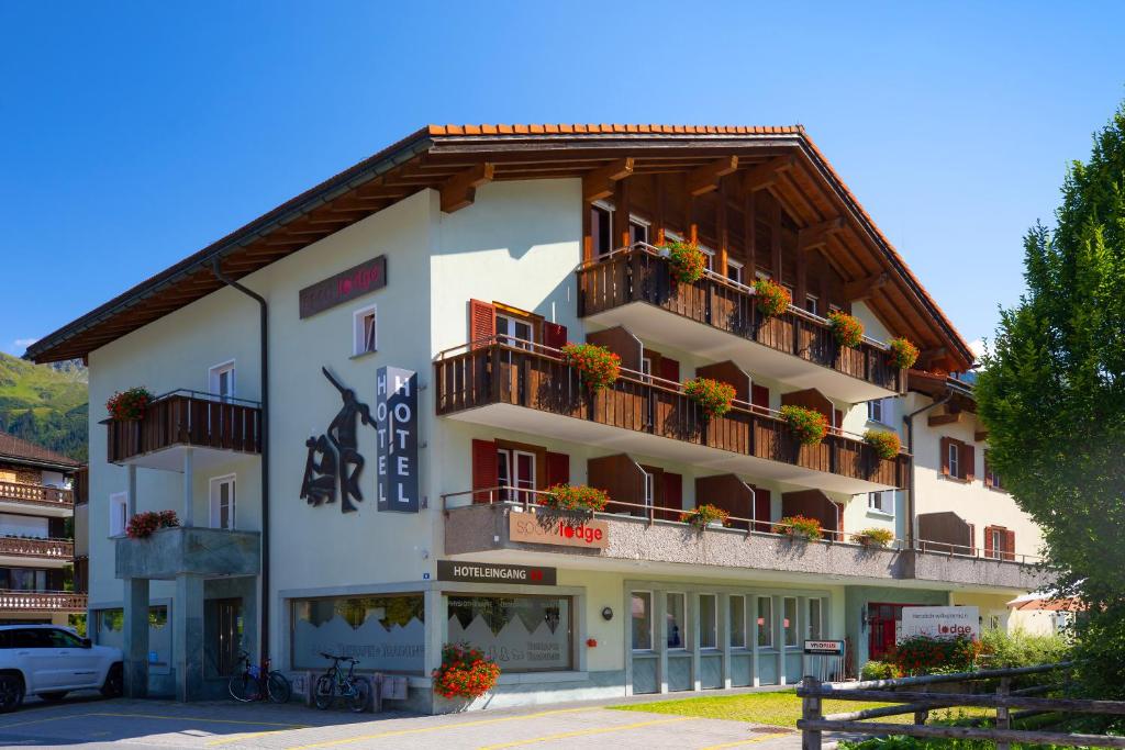 a large white building with flowers on the balconies at Sport-Lodge Klosters in Klosters