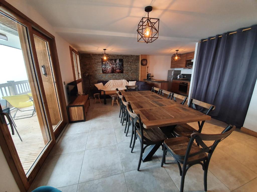 une salle à manger avec une table et des chaises en bois dans l'établissement Le Repaire des Loups - Appart neuf 12 pers 4 chambres - location à la semaine, à Saint-François-Longchamp